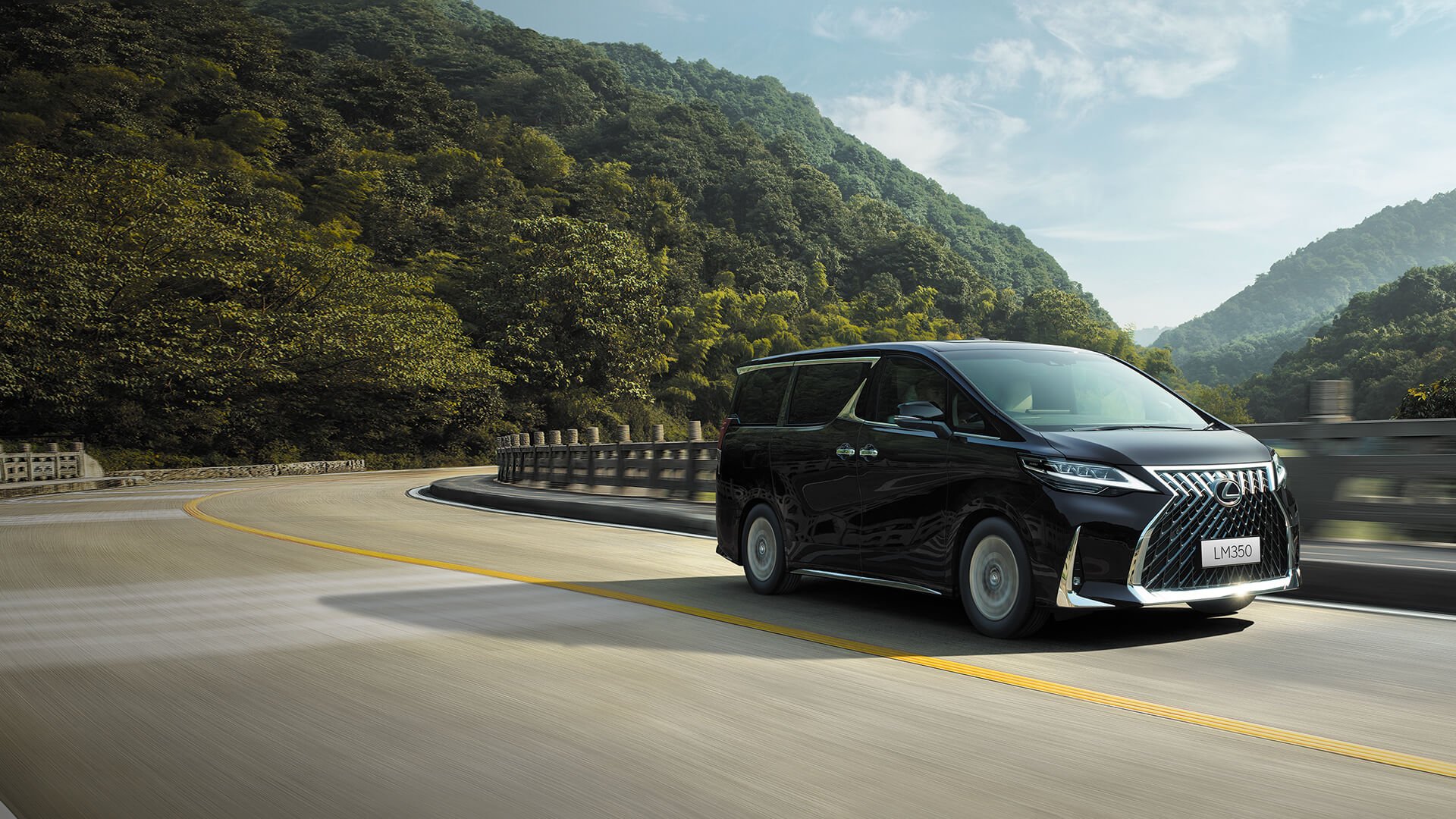 Black Lexus LM being driven on the road.